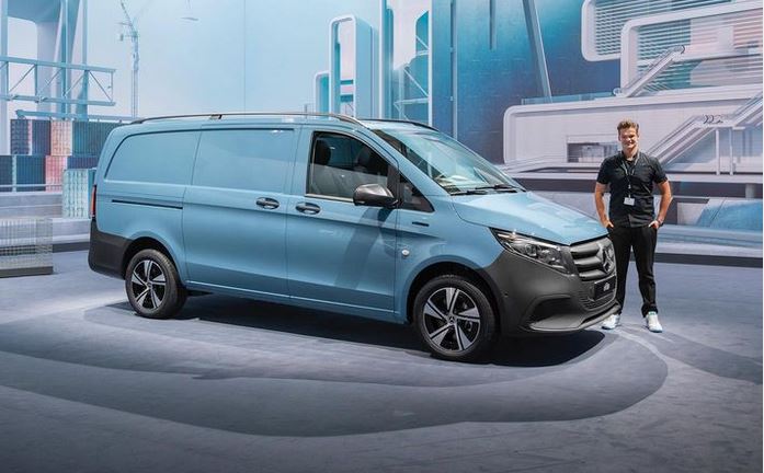 Volontär Tim Buttler steht auf einer Presseveranstaltung von Mercedes-Benz in Wiesbaden neben einem Midsize-Van